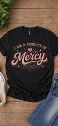 I Am a Product of Mercy graphic tee in rose gold on black, flat lay